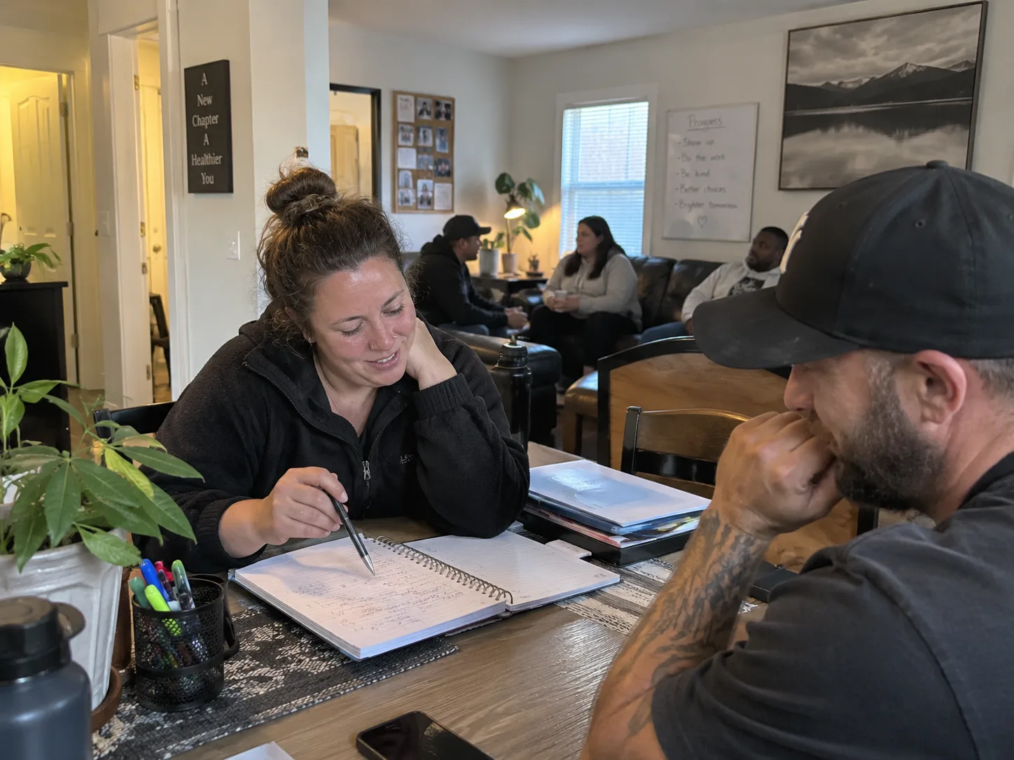 A woman and man reviewing a notebook and planning next steps