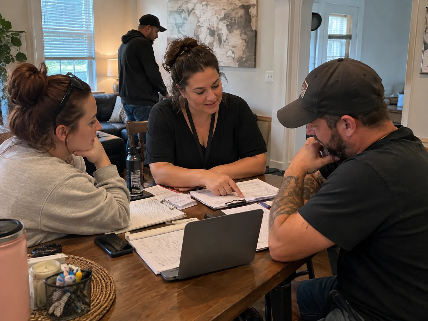 A mixed group working together around a table with notebooks and laptops